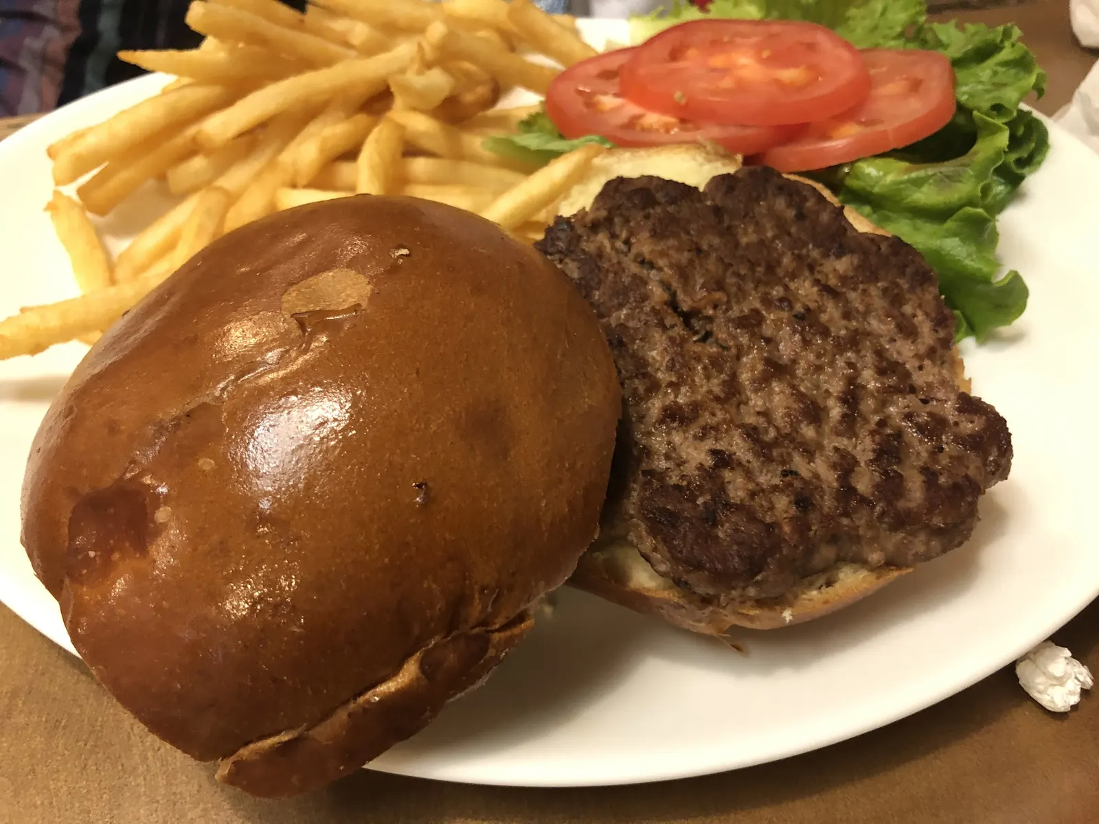 A burger with fries, lettuce and tomato at Romanelli's