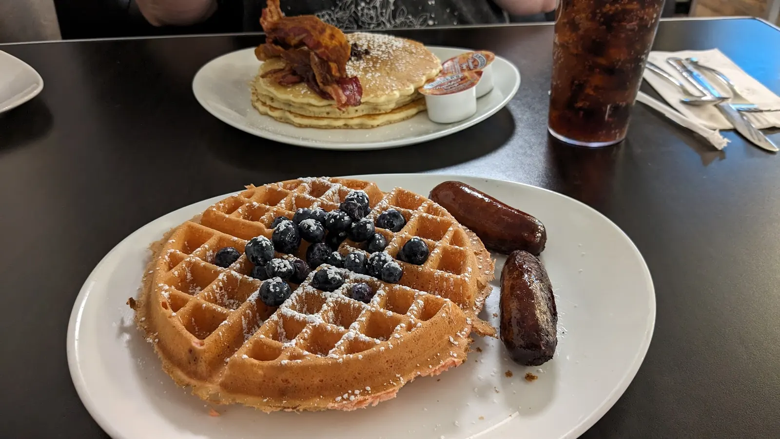 Waffles with blueberries and a plate of pancakes at Romanelli's